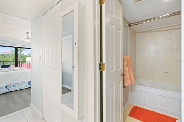 bathroom with tile flooring, ceiling fan, and tiled shower / bath