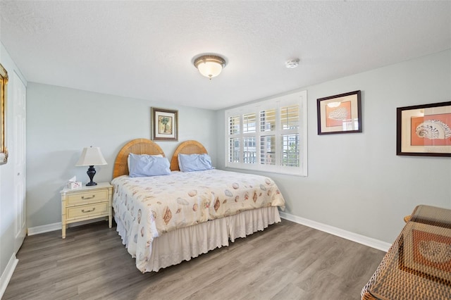 bedroom with hardwood / wood-style floors and a textured ceiling