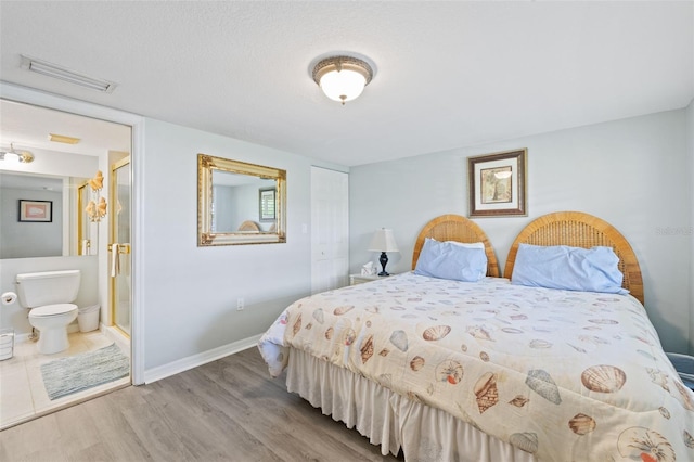 bedroom featuring hardwood / wood-style flooring and ensuite bathroom