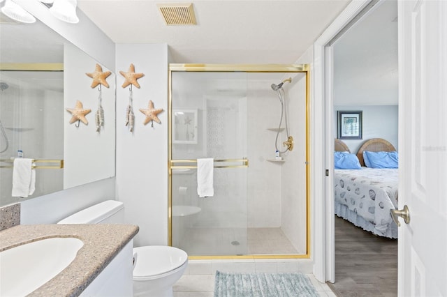 bathroom featuring vanity, hardwood / wood-style floors, a shower with shower door, and toilet