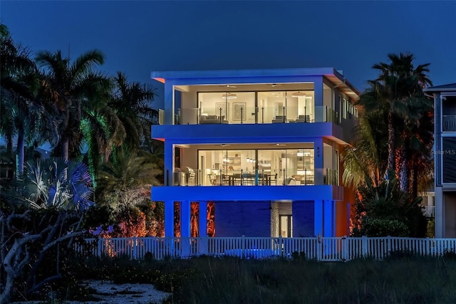 back house at night with covered porch and a balcony