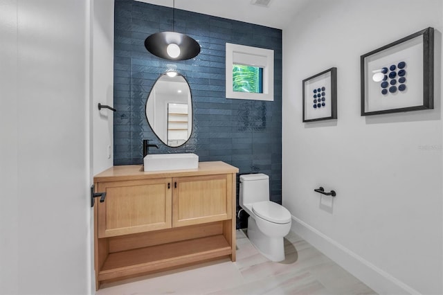 bathroom featuring vanity, toilet, tile patterned floors, and tile walls