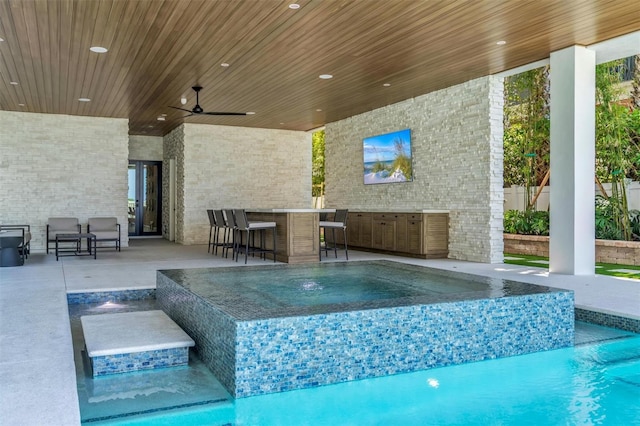 view of pool with a patio area, pool water feature, and ceiling fan