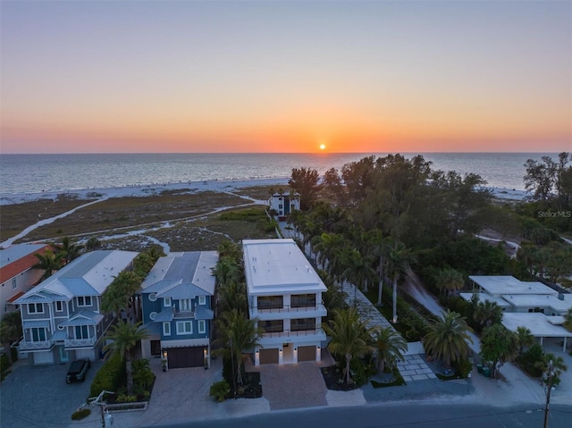 aerial view at dusk featuring a water view