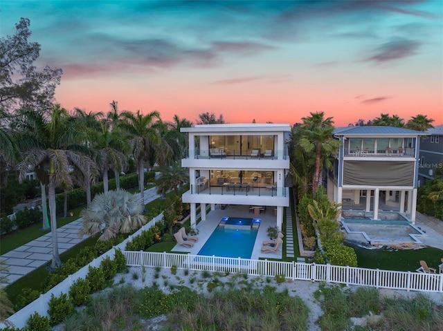 back house at dusk with a balcony