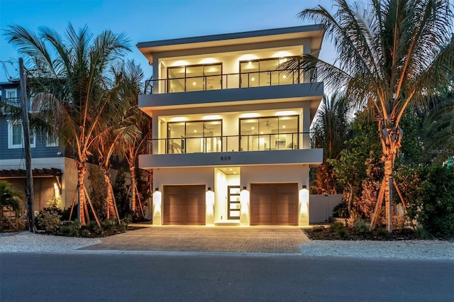 contemporary house featuring a garage and a balcony