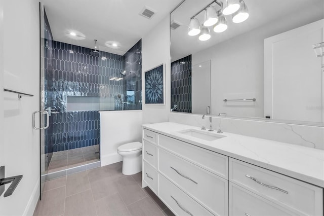 bathroom featuring an enclosed shower, vanity, tile patterned flooring, and toilet