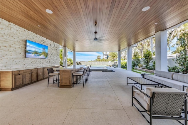 view of patio with an outdoor living space, exterior bar, a pool, and ceiling fan