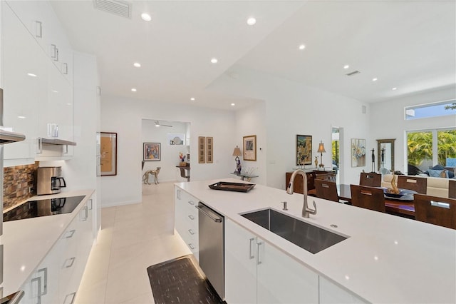 kitchen with light tile floors, white cabinets, sink, stainless steel dishwasher, and black electric stovetop