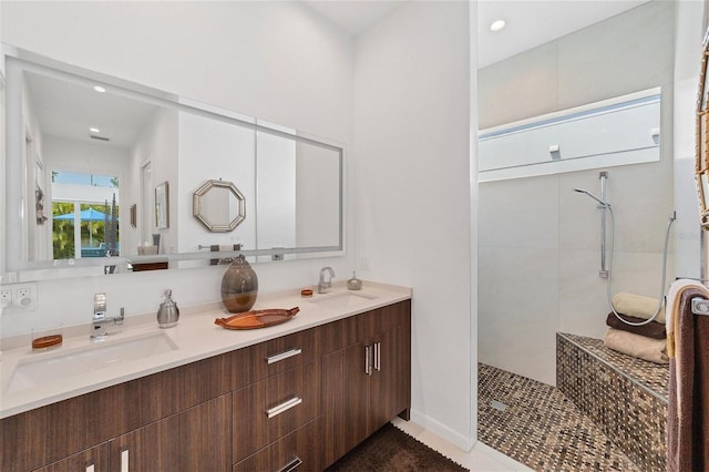 bathroom featuring double vanity and a tile shower