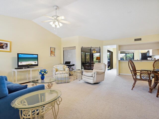 living room featuring ceiling fan, carpet floors, and vaulted ceiling