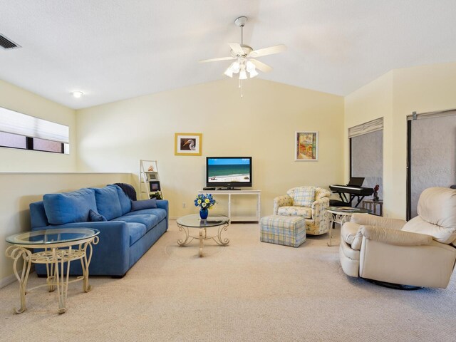 living room featuring lofted ceiling, ceiling fan, and carpet