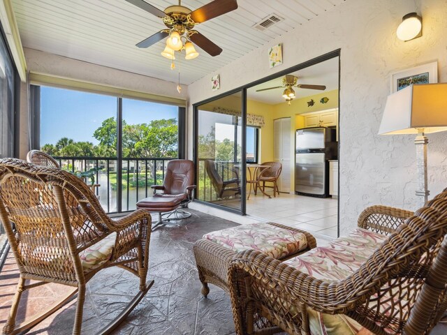 sunroom / solarium featuring ceiling fan