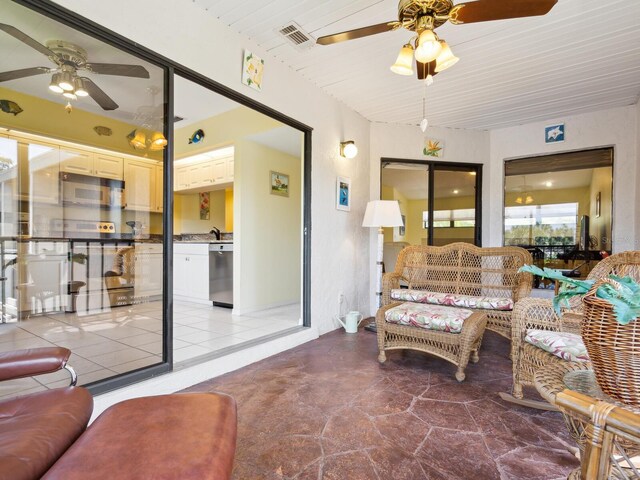 tiled living room with ceiling fan and sink