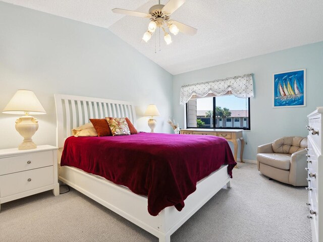 carpeted bedroom with lofted ceiling, ceiling fan, and a textured ceiling