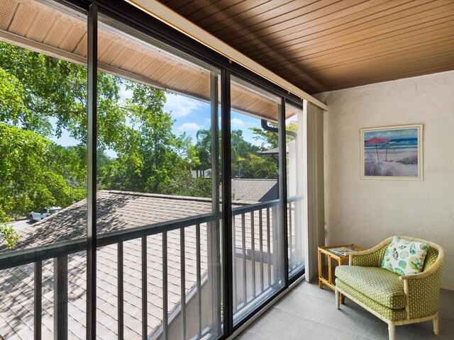 sunroom / solarium featuring wood ceiling and a healthy amount of sunlight