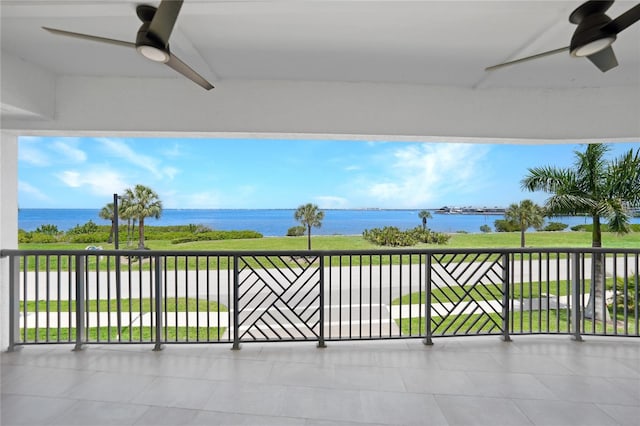 view of patio / terrace featuring a balcony, ceiling fan, and a water view