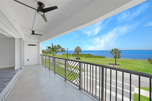 balcony with ceiling fan and a water view