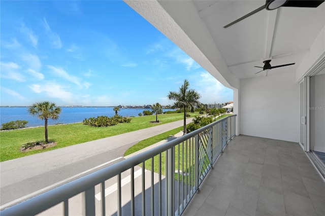 balcony with ceiling fan and a water view