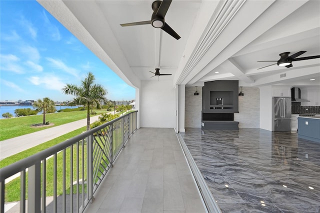 balcony with a water view and ceiling fan