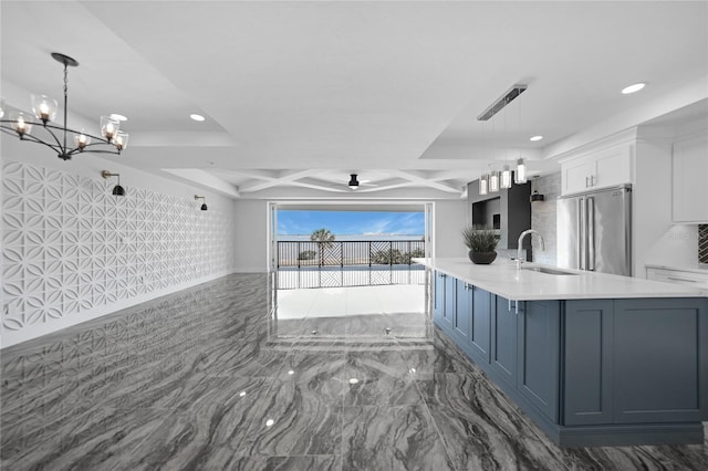 kitchen with decorative light fixtures, white cabinets, high end fridge, sink, and coffered ceiling