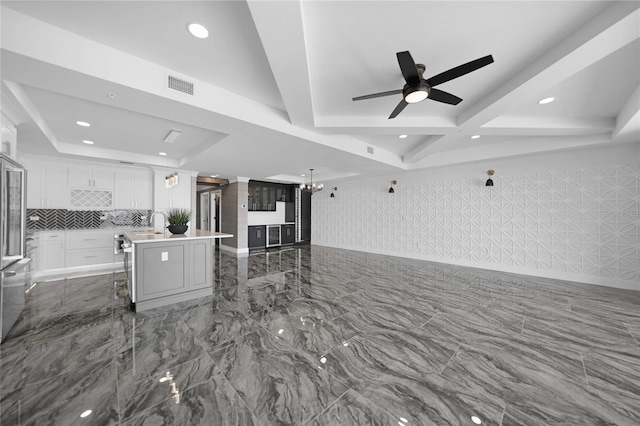 kitchen featuring a breakfast bar, tile floors, ceiling fan, and an island with sink