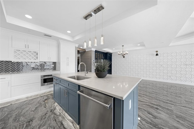 kitchen featuring white cabinets, sink, stainless steel appliances, and a raised ceiling