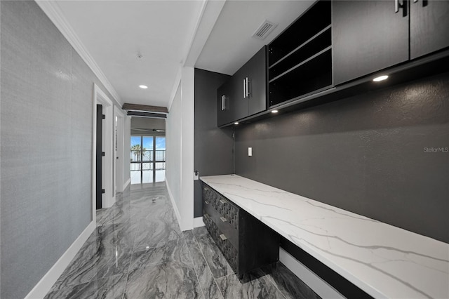 interior space featuring ornamental molding, light tile floors, and light stone countertops