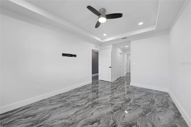 unfurnished room featuring ceiling fan, tile floors, and a tray ceiling