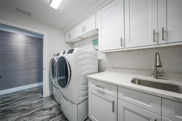 clothes washing area with sink, dark tile flooring, cabinets, and washing machine and dryer