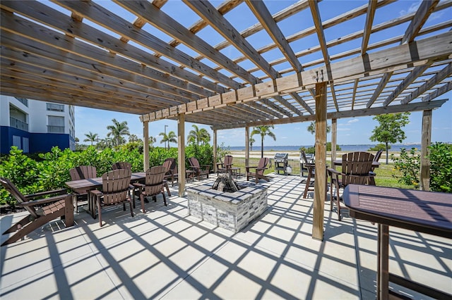 view of patio / terrace with an outdoor fire pit, a water view, and a pergola