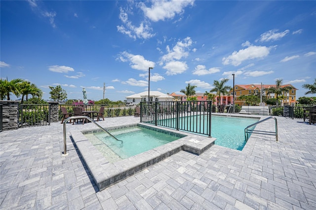 view of pool featuring a hot tub and a patio