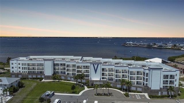 aerial view at dusk featuring a water view