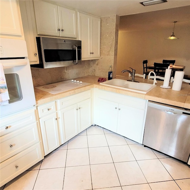 kitchen with white cabinets, sink, appliances with stainless steel finishes, and light tile flooring