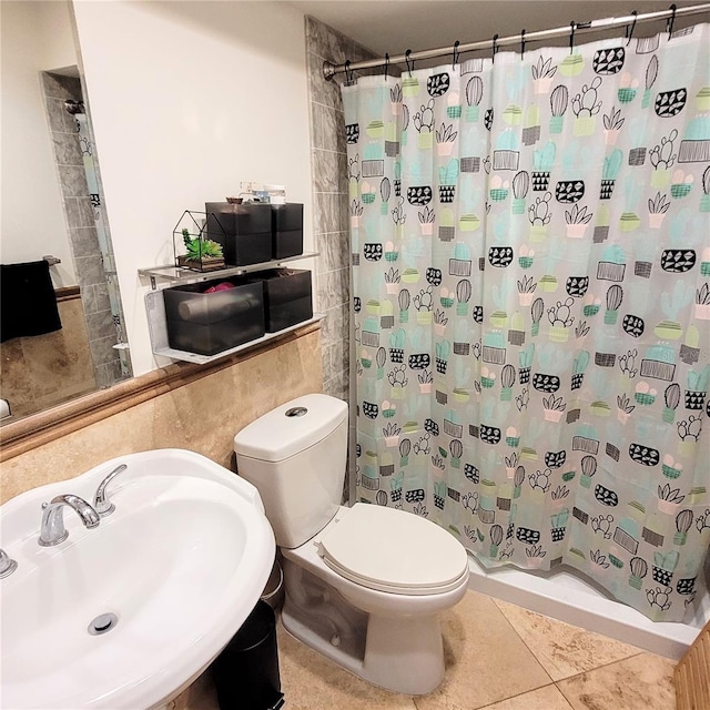 bathroom featuring tile flooring, sink, and toilet