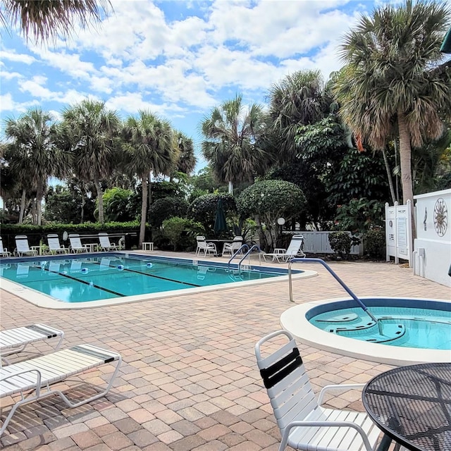 view of pool with a patio and a hot tub