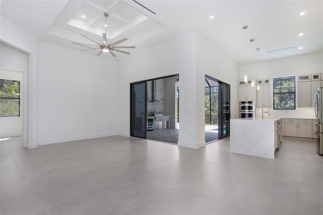 4111 Williams Rd, Estero, FL 33928 - unfurnished living room featuring a towering ceiling, baseboards, a sink, and recessed lighting