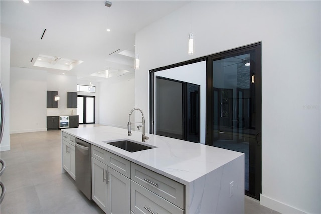 4111 Williams Rd, Estero, FL 33928 - kitchen featuring stainless steel dishwasher, open floor plan, a kitchen island with sink, a sink, and light stone countertops
