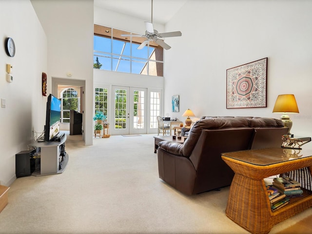 carpeted living room with high vaulted ceiling, french doors, and ceiling fan