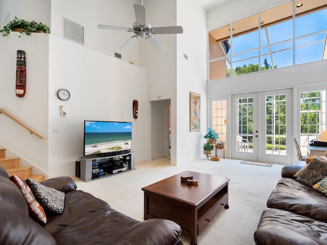 living room featuring a high ceiling, ceiling fan, french doors, and carpet floors