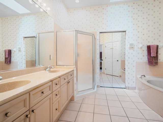 bathroom featuring a skylight, double vanity, separate shower and tub, and tile floors