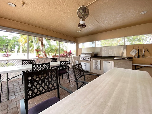 exterior space with a bar, area for grilling, and ceiling fan