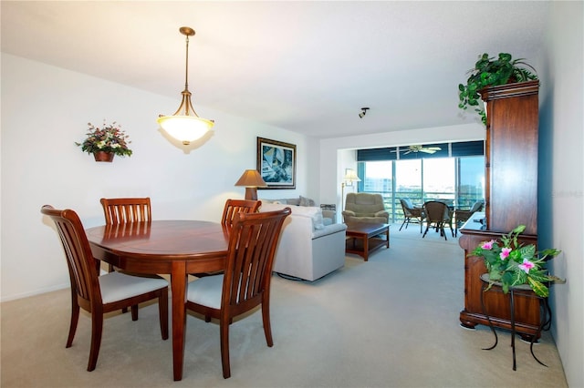 carpeted dining room with ceiling fan