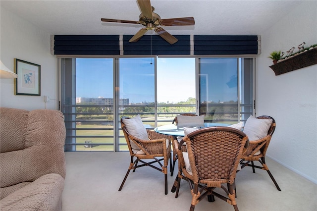 dining space featuring ceiling fan and carpet flooring