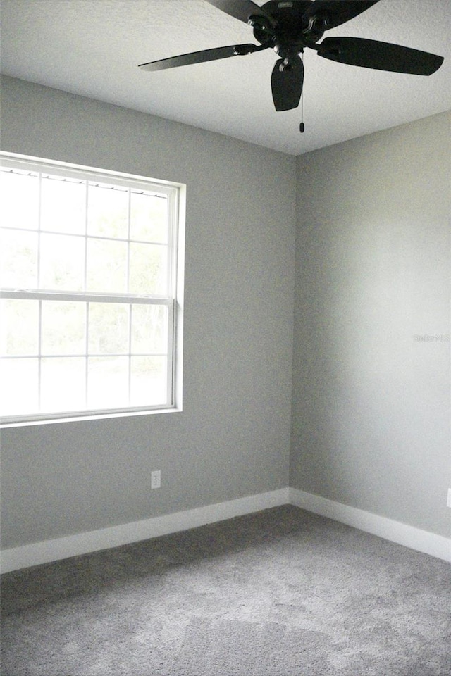 carpeted empty room featuring ceiling fan