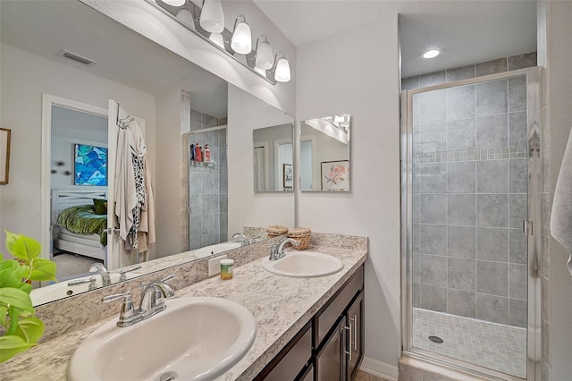 bathroom featuring an enclosed shower and dual vanity