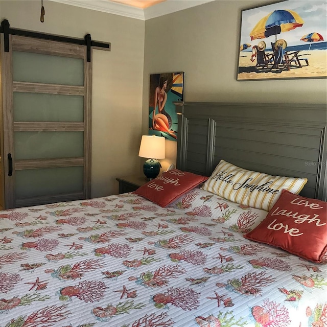 bedroom with ornamental molding and a barn door