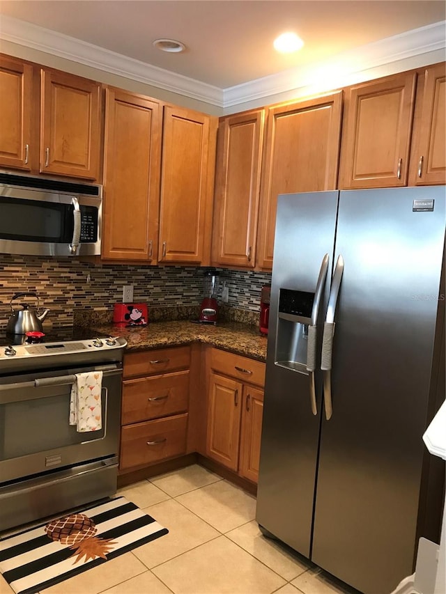 kitchen featuring backsplash, light tile floors, stainless steel appliances, and crown molding