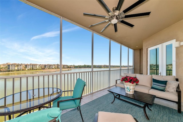 sunroom / solarium featuring a water view and ceiling fan