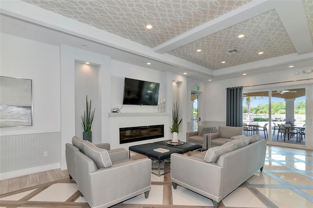 living room featuring ceiling fan and a tray ceiling